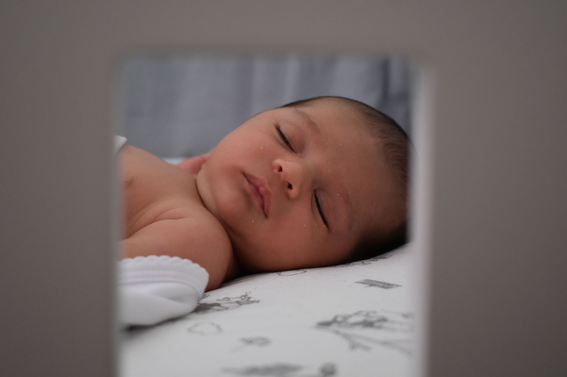 Un bébé de cinq mois dort paisiblement dans son lit.